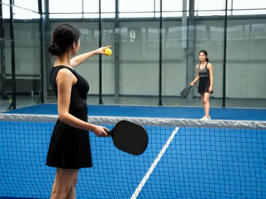 Padel player striking the ball on an indoor court